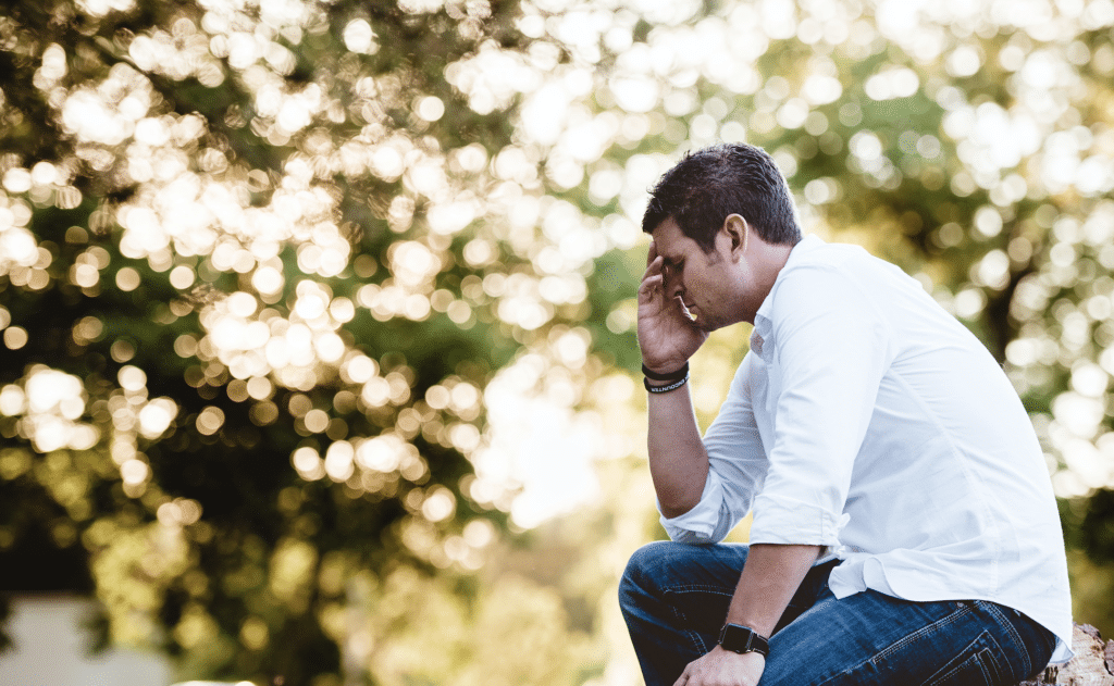 Man sitting frustrated on park bench